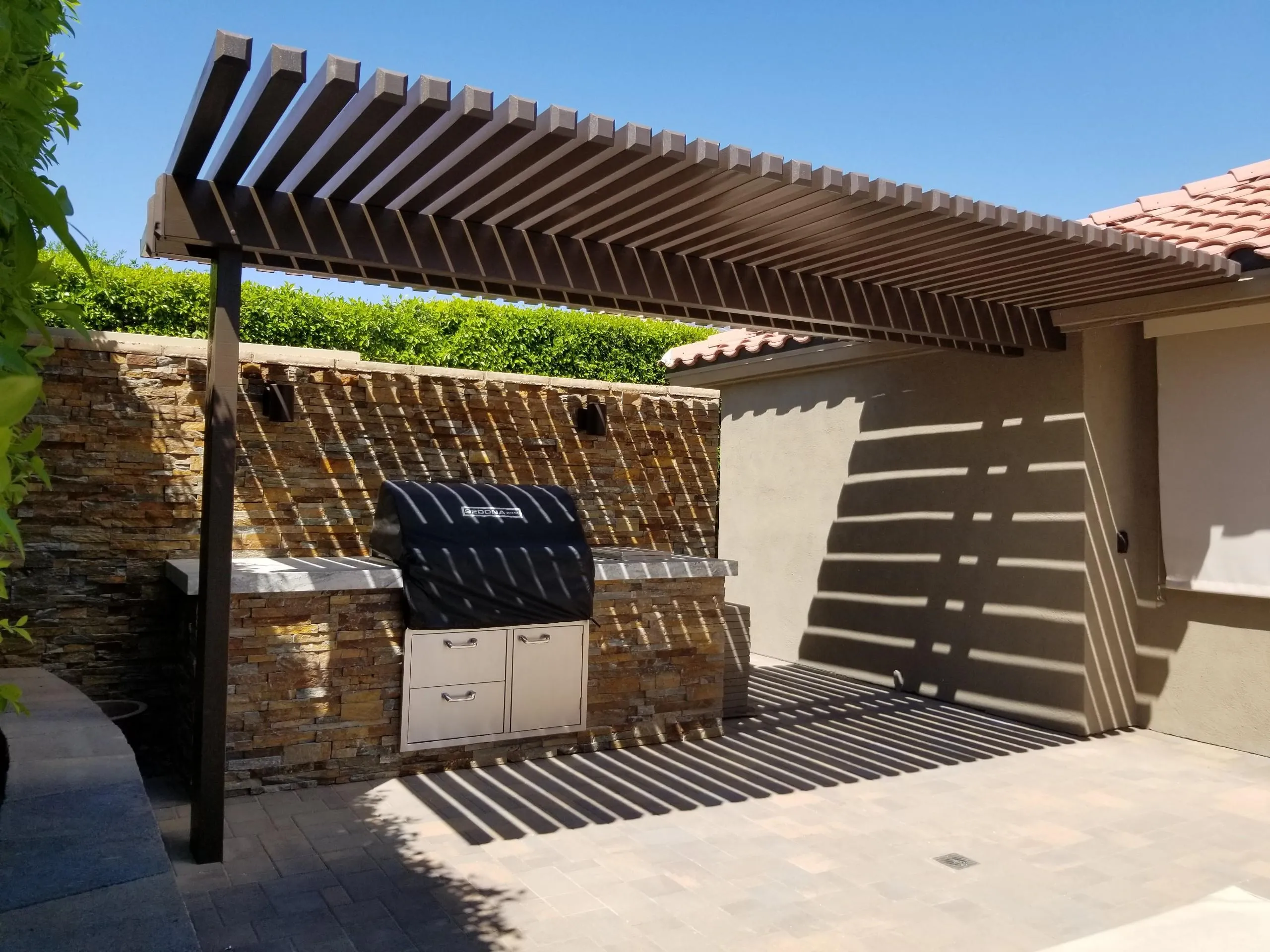 Weatherwood aluminum pergola for a backyard barbecue area