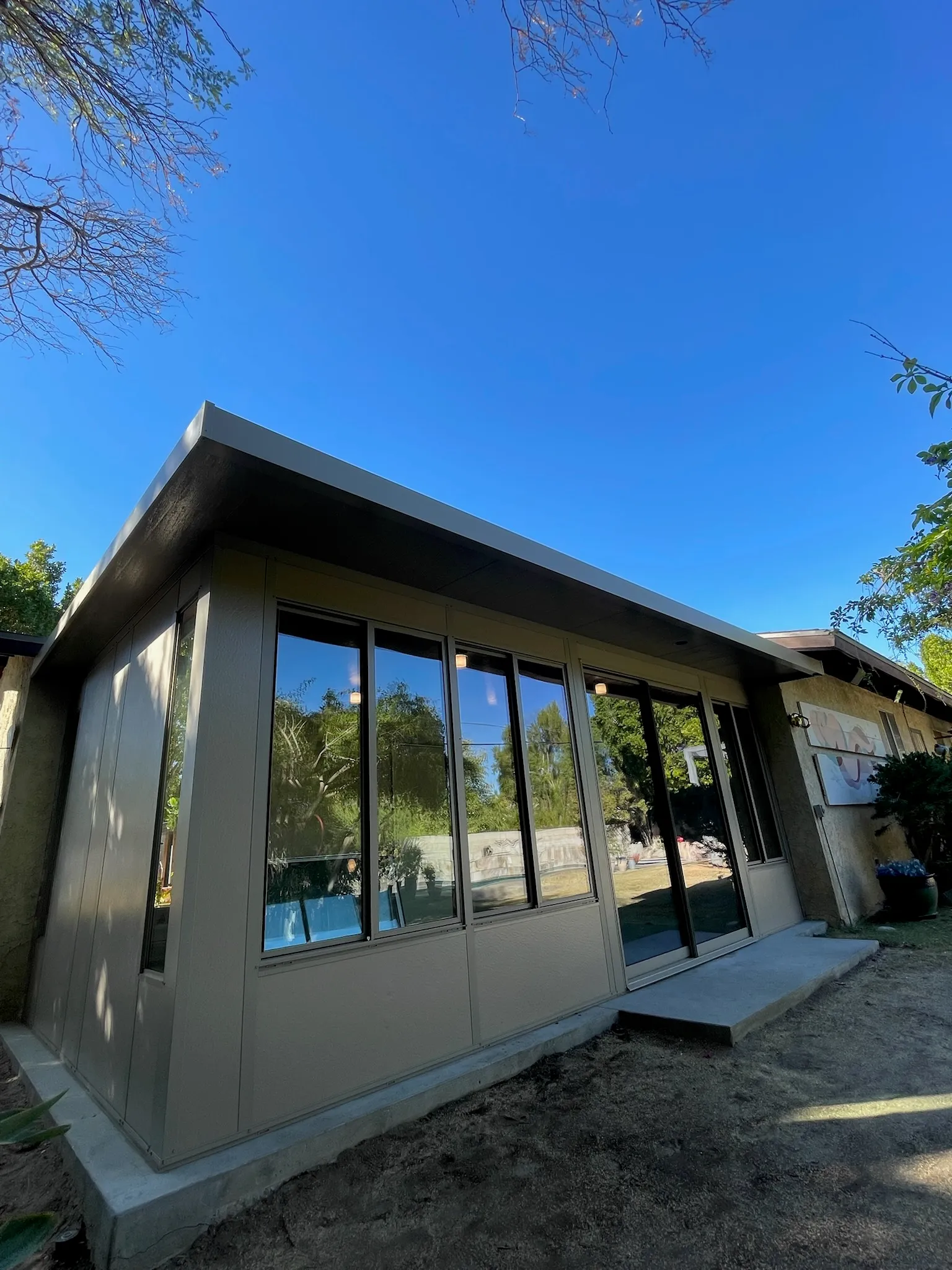 Duralum room enclosure in driftwood finish for a covered outdoor space
